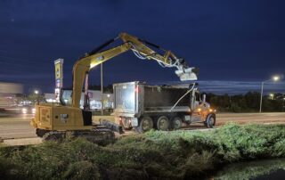 Foley crews use an excavator to clear drainage ditches at night ahead of Hurricane Isaias.